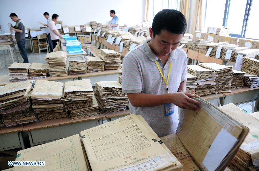 College entrance exam paper marking review staff work at a paper marking room in the Northwest Normal University in Lanzhou, capital of northwest China's Gansu Province, June 13, 2013. In total 2,150 paper marking staff members need to mark the exam papers of 283,424 participants of 2013 college entrance exam in Gansu from June 10 to June 22. (Xinhua/Fan Peikun)  