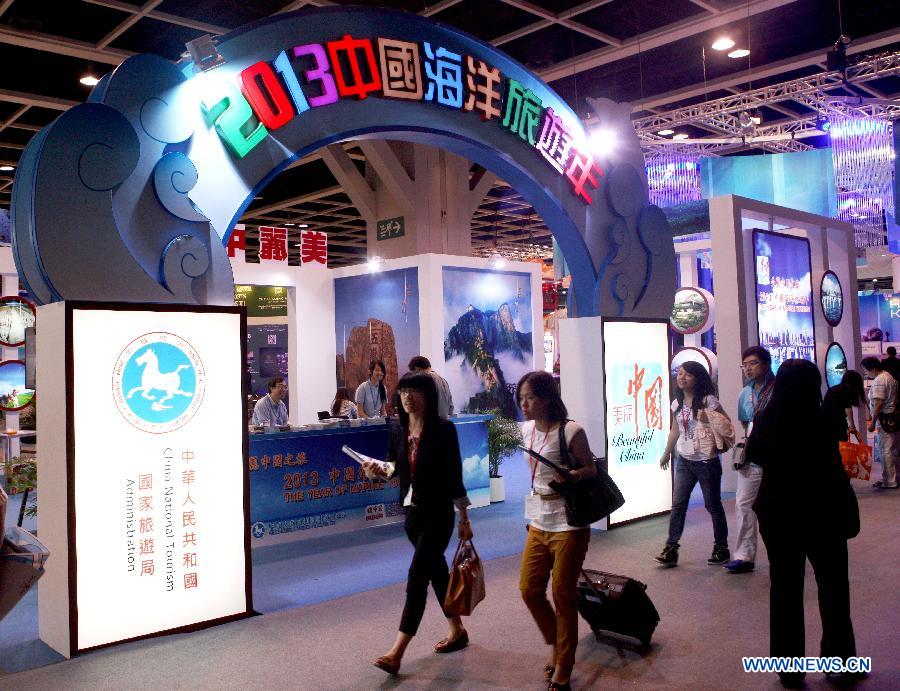 People walk past the exhibition stand of China National Tourism Administration at the 27th Hong Kong International Travel Expo in south China's Hong Kong, June 13, 2013. The four-day expo kicked off here on Thursday at Hong Kong Convention & Exhibition Centre. (Xinhua/Wang Yuqing)