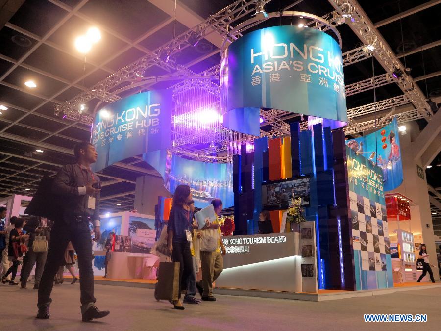 People walk past the exhibition stand of Hong Kong Tourism Board at the 27th Hong Kong International Travel Expo in south China's Hong Kong, June 13, 2013. The four-day expo kicked off here on Thursday at Hong Kong Convention & Exhibition Centre. (Xinhua/Li Ying)