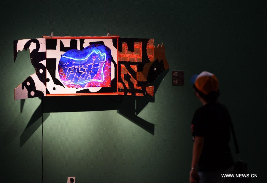 A visitor views artworks at an exhibition showcasing creations by Spanish art master Jose de Guimaraes at the Shaanxi Province Art Museum in Xi'an, northwest China's Shaanxi Province, June 14, 2013. The exhibition kicked off here on June 13 and displayed some 70 creations. (Xinhua/Li Yibo)