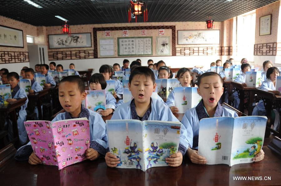 Students read Chinese classics at Shuangqiao Primary School in Pingquan County, north China's Hebei Province, June 14, 2013. Learning Chinese classics, like the Three-Character Classic and the Analects of Confucius, for one class hour per week has been part of the curriculum for students in Shuangqiao Primary School since 2009. (Xinhua/Wang Xiao)