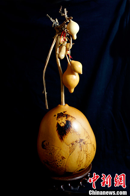 In recent years, gourd pyrography has getting increasingly popular and attracts many fans. It can be seen in many antique markets, auctions and craft markets. Gourd pyrography is also called pyrography or “huo bi hua”. Artists paint on gourds with electric irons. Gourds have been given the meanings of “good luck and happiness” in traditional Chinese culture. Gourd pyrography originated in Song Dynasty. Emperor Kangxi in Qing Dynasty loved gourd art. He always asked his artists in court to make exquisite gourd artworks. This picture shows the work of the pyrography master Zhang Ai from Tianjin. Zhang majored in oil painting. Her masterpiece “Zhongkui” learned from traditional artworks and focused on relations between virtuality and reality, far and near, light and shadow. It is vivid and full of vitality. (CNS/Zhangyu)