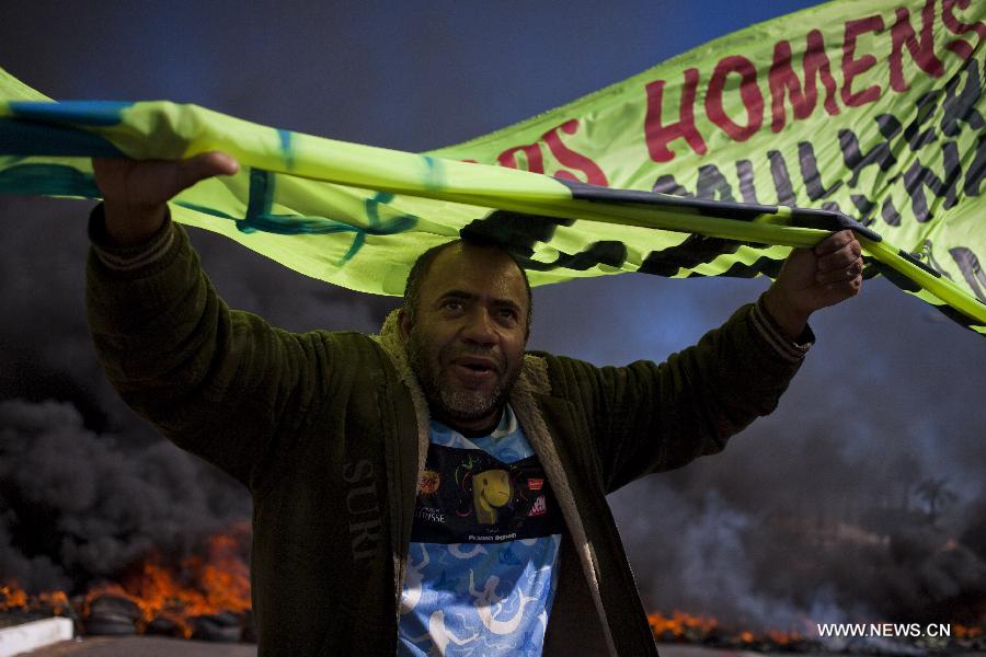 A man holds a banner during a protest in front of the Mane Garrincha National Stadium, in Brasilia, Brazil, on June 14, 2013. The 2013 FIFA Confederations Cup will be held from June 15 to 30, 2013. (Xinhua/Guillermo Arias)