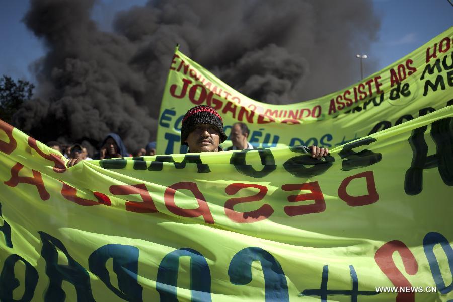 A man holds a banner during a protest in front of the Mane Garrincha National Stadium, in Brasilia, Brazil, on June 14, 2013. The 2013 FIFA Confederations Cup will be held from June 15 to 30, 2013. (Xinhua/Guillermo Arias)