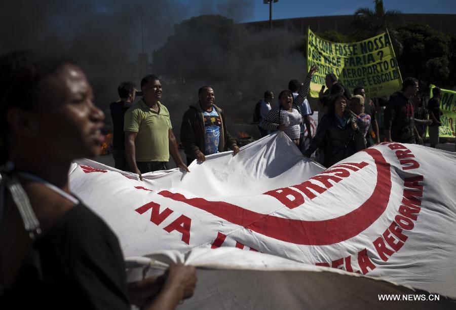 Residentes attend a protest in front of the Mane Garrincha National Stadium, in Brasilia, Brazil, on June 14, 2013. The 2013 FIFA Confederations Cup will be held from June 15 to 30, 2013. (Xinhua/Guillermo Arias)