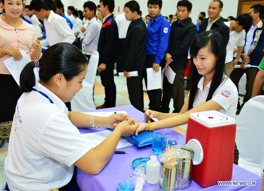 People do body check before donating blood on the occasion of the World Blood Donor Day in Vientiane, Laos, June 14, 2013. Over 1,000 local people donated blood on the 10th World Blood Donor Day. (Xinhua/Liu Ailun)