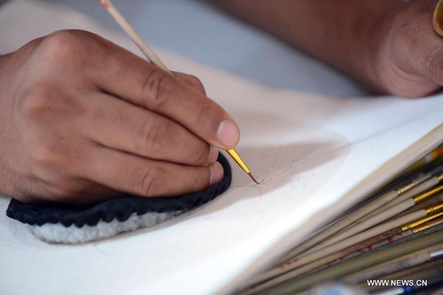 An artist makes a Thangka at the 4th International Festival of Intangible Cultural Heritage in Chengdu, capital of southwest China's Sichuan Province, June 15, 2013. The nine-day festival kicked off here on Saturday. (Xinhua/Li Xiangyu)