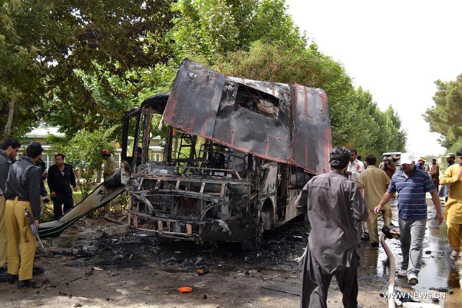 People gather at the blast site in southwest Pakistan's Quetta, June 15, 2013. At least 11 people were killed and 22 others injured as a blast hit a university bus in Pakistan's southwest city of Quetta on Saturday afternoon, police said. (Xinhua/Asad) 