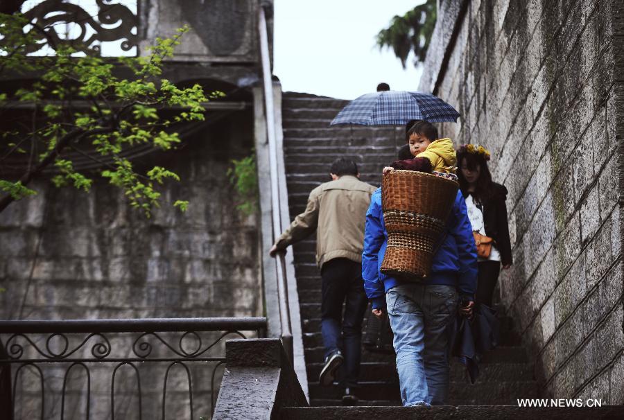 A child is seen in a pack basket on his father's back while touring in the Fenghuang ancient town in central China's Hunan Province, April 9, 2013. The third Sunday in June marks the Father's Day, which falls on June 16 this year. (Xinhua/Cheng Tingting) 