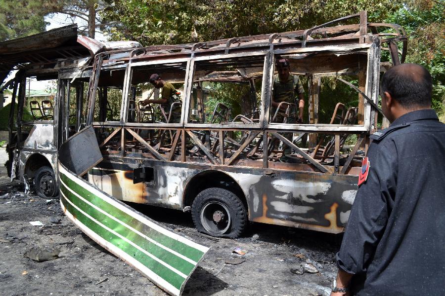 Pakistani security personnel inspect the burnt student bus a day after it was destroyed by a bomb blast in southwest Pakistan's Quetta, June 16, 2013. A day of mourning was observed across Pakistan's southwestern Balochistan province on Sunday over Saturday's bombings targeting the Women University bus and the Bolan Medical Complex which has claimed 20 precious lives. (Xinhua/Asad)