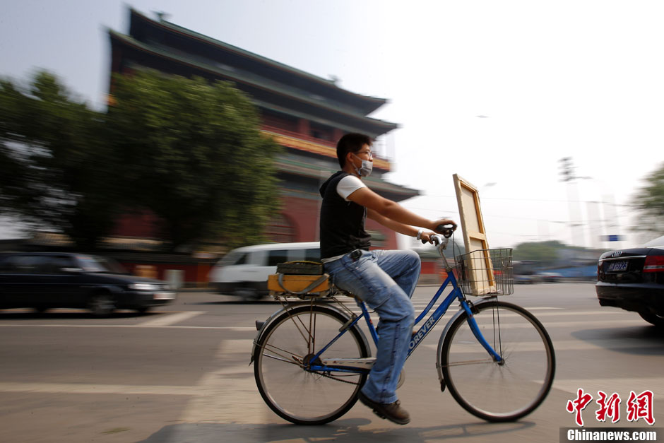 Fucha rides his bicycle near the Drum Tower where he always has his paintings done. He wanders all around to pick the painting spot.(CNS/Fu Tian)