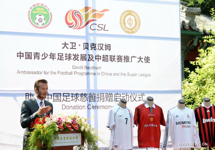 Recently retired football player David Beckham delivers a speech during a donation ceremony in Beijing, capital of China, June 17, 2013. As the ambassador for the Football Programme in China and China's Super League, Beckham donated various team jerseys he wore during his career to a children's charity in China. David Beckham is joined by his wife Victoria during a seven day visit in China starting today. (Xinhua/Guo Yong)