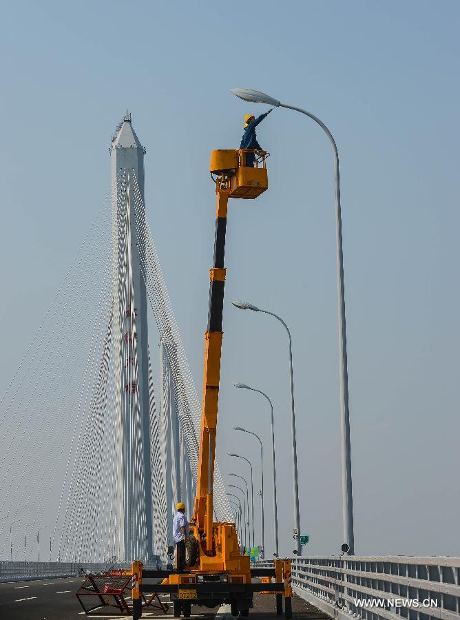 Electricians work on the Jiaxing-Shaoxing Sea Bridge in Shaoxing, east China's Zhejiang Province, June 17, 2013. The bridge was completed on June 17 and is expected to be open to traffic by the end of June. With a span of 10 kilometers over the Hangzhou Bay, it is the world's longest and widest multi-pylon cable-stayed bridge. (Xinhua/Xu Yu) 