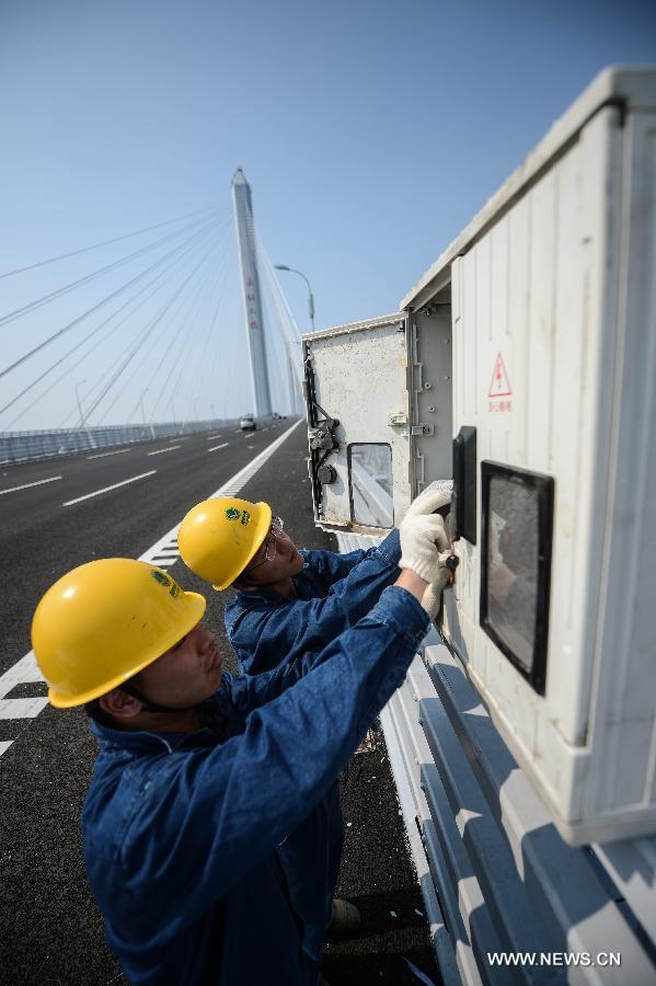 Electricians work on the Jiaxing-Shaoxing Sea Bridge in Shaoxing, east China's Zhejiang Province, June 17, 2013. The bridge was completed on June 17 and is expected to be open to traffic by the end of June. With a span of 10 kilometers over the Hangzhou Bay, it is the world's longest and widest multi-pylon cable-stayed bridge. (Xinhua/Xu Yu) 