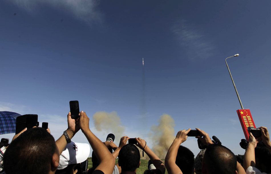 Spectators take photos of the manned Shenzhou-10 spacecraft at the Jiuquan Satellite Launch Center in Jiuquan, northwest China's Gansu province, June 11, 2013. (Xinhua)