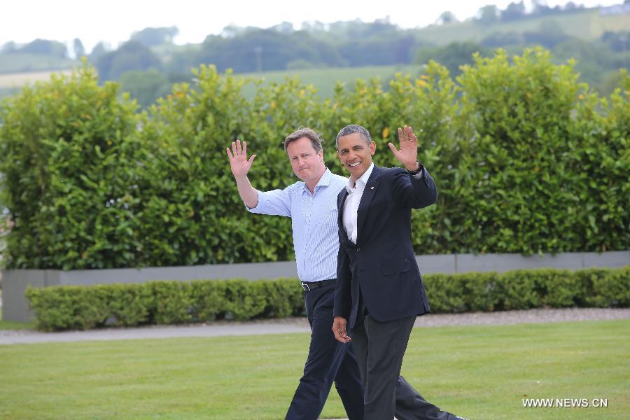 Britain's Prime Minister David Cameron (L) and U.S. President Barack Obama wave hands during the the official welcome as world leaders arrive for the openning ceremony of the G8 Summit at the Lough Erne resort near Enniskillen in Northern Ireland June 17, 2013. The focus of the Group of Eight (G8) industrialized nations' annual summit were expected to be on Syria and economic issues. (Xinhua/Yin Gang)