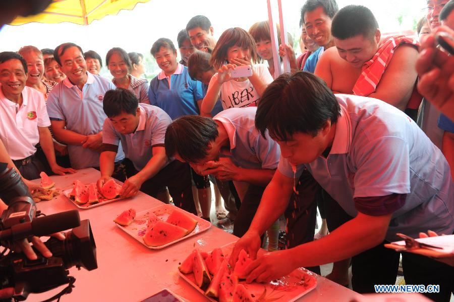 People take part in a watermelon-eating contest during a watermelon festival in Fucheng County, north China's Hebei Province, June 18, 2013. The Fucheng County is a well-known watermelon growing area in north China, which grows 119,000 mu (about 8,000 hectares) watermelons and produces 550,000 tonnes of watermelons annually, with the annual sales volume reaching about 1 billion yuan (163.2 million U.S. dollars). (Xinhua/Wang Min)