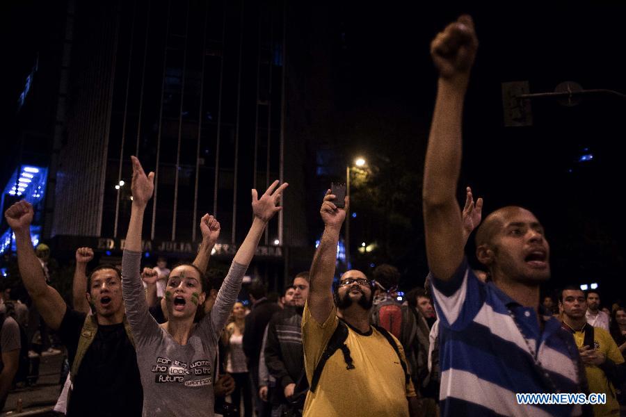 Young students shout slogans during a protest against the millions of dollars Brazilian government spending for the FIFA Confederations Cup Brazil 2013 and World Cup Brazil 2014, at the Obelisco of Belo Horizonte, Minas Gerais state, Brazil, on June 17, 2013. The FIFA Confederations Cup Brazil 2013 is held from June 15 to June 30. (Xinhua/David de la Paz)