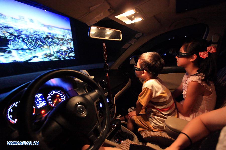 A family watches a film in car in the open-air drive-in theatre in a self-drive encampment near Wuyi Mountain, southeast China's Fujian Province, June 17, 2013. The first 3D drive-in theatre of the Fujian Province opened here recently, which occupies 5,000 square meters and can accommodate 86 cars. (Xinhua/Yi Fan) 