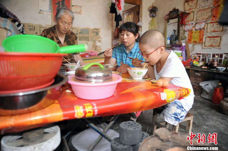 Ms. Xue, her mother and daughter have noodles for lunch after Hao Xin was back from hospital. Having a meal in the restaurant is an extravagant expectation for this family. (Photo/CNS) 