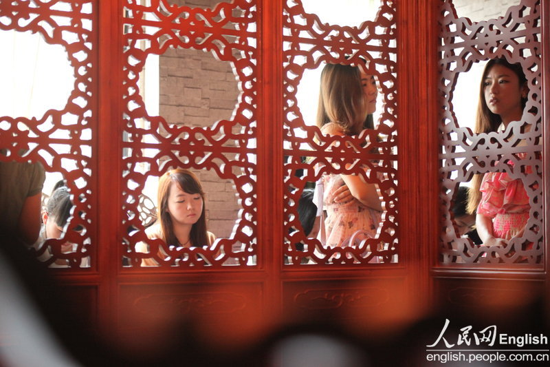 The candidates wait for their turns during a "rich blind date" held in Jinan, capital city of east China's Shandong province, June 16, 2013. Fifty candidates taking part in the "rich blind date" will be selected to attend a party for rich individuals to be held overseas in July. (Photo by Pan Yongqiang/ CFP)