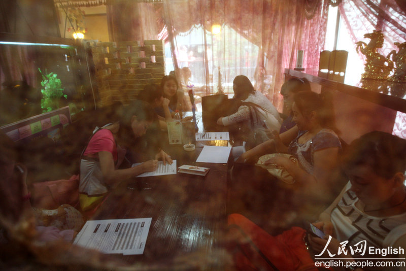 Candidates fill in forms prior to a so-called "rich blind date" held in Jinan, capital city of east China's Shandong province, June 16, 2013. Fifty candidates taking part in the "rich blind date" will be selected to attend a party for rich individuals to be held overseas in July. (Photo by Pan Yongqiang/ CFP)