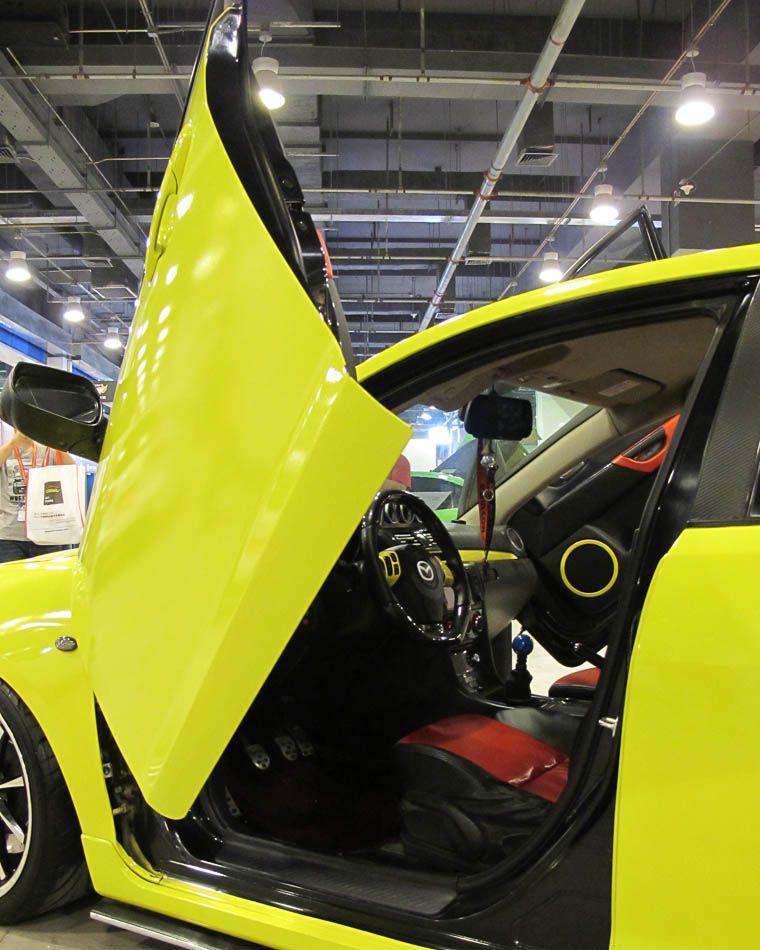 A modified Mazda car displayed with its scissor door opened at the 'All in Tuning All in Caravanning' Show China 2013 on June 15, 2013, at the China National Convention Center, Beijing. [Hao Yan / chinadaily.com.cn]