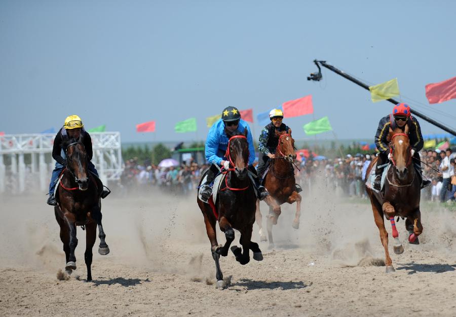 Herdsmen of the Owenke ethnic group participate in a horse race at the annual Sebin (Happiness) Festival in Owenke Autonomous Banner, north China's Inner Mongolia Autonomous Region, June 18, 2013. The Owenke ethnic group has the reputation of the "last hunting tribe in China". (Xinhua/Liu Yongzhen)
