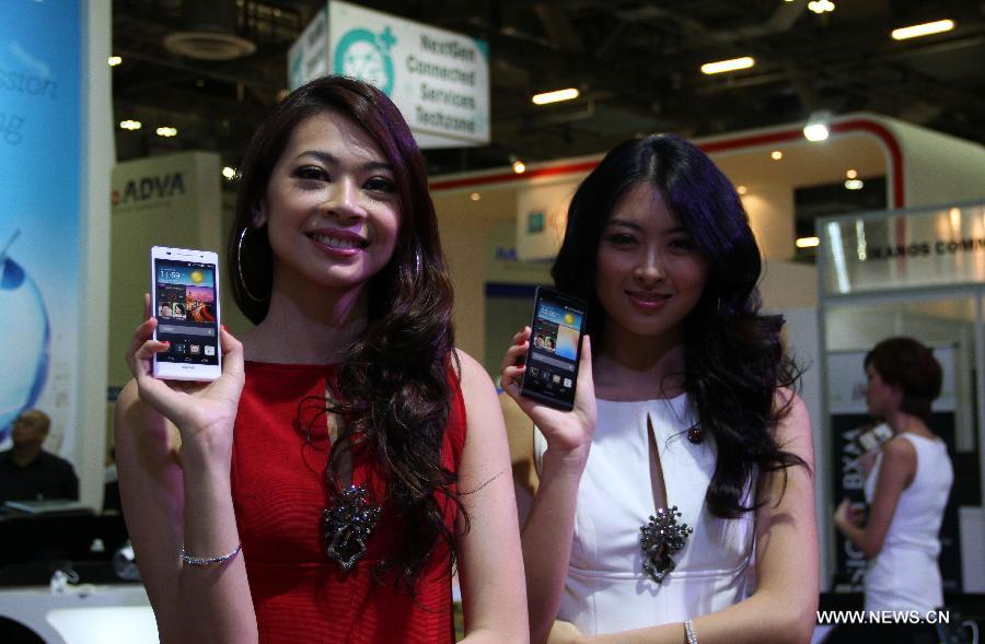 Models show Huawei Ascend P6 smartphones at Huawei's booth during the CommunicAsia in Singapore, on June 19, 2013. International telecommunications giant Huawei unveiled its latest flagship device Ascend P6 in Singapore on Wednesday, marketing it as the thinnest smartphone in the world. (Xinhua/Chen Jipeng)