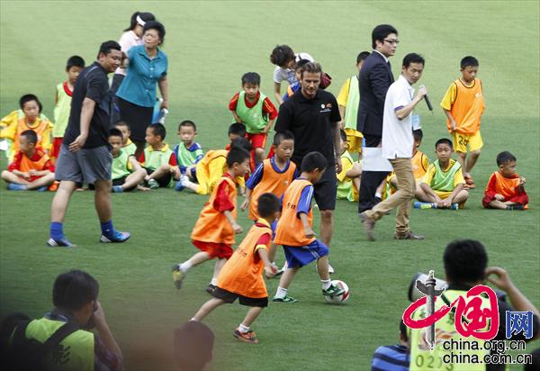 Recently retired football player David Beckham takes part in a training session with students at Nanjing Olympic Center in Nanjing, east China's Jiangsu Province, June 18, 2013. Beckham is on a seven-day visit to China as the ambassador for the Football Programme in China and China's Super League. (Photo/China.org.cn)