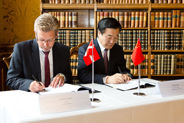 Mayor of Copenhagen Frank Jensen (L) and Deputy Mayor of Beijing Li Shixiang sign a memorandum on tourism cooperation in Copenhagen, Denmark, June 19, 2013. (Xinhua/Ursula Bach)