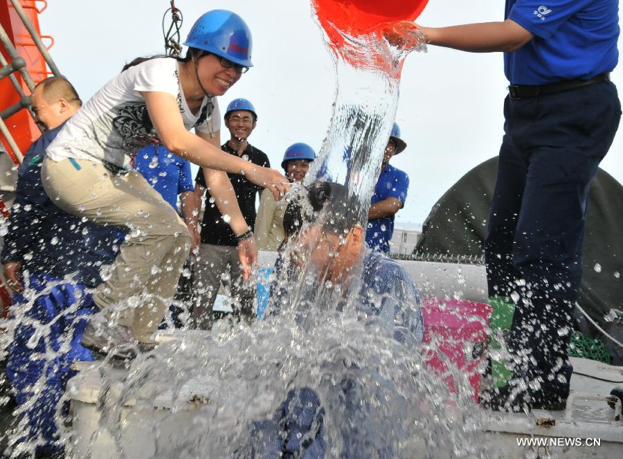 Staff members welcome Qiu Jianwen, a professor from Hong Kong Baptist University, to celebrate his return with China's manned deep-sea submersible Jiaolong after a sample-capture mission in the cold vents of south China sea, south China, June 19, 2013. Qiu obtained deep-sea samples in the cold vents of the South China Sea during a dive conducted on Wednesday. (Xinhua/Zhang Xudong)