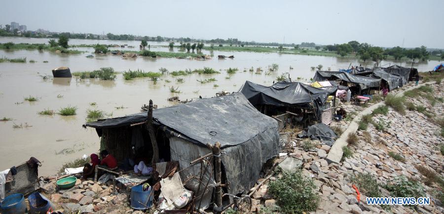 Tents are set up along the banks of the Yamuna River in New Delhi, India, June 19, 2013. The Indian capital has been put on flood alert after its main Yamuna river breached the danger mark following incessant rainfall since June 16. (Xinhua/Partha Sarkar)