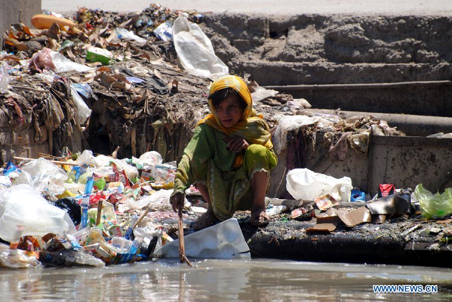 An Afghan refugee girl searches for reusable materials from a garbage dump on the eve of World Refugee Day in northwest Pakistan's Peshawar, June 19, 2013. There are 1.65 million registered Afghans currently living in Pakistan. Since 2002, UNHCR's voluntary repatriation program has assisted more than 3.8 million Afghan refugees to return home. (Xinhua/Umar Qayyum)