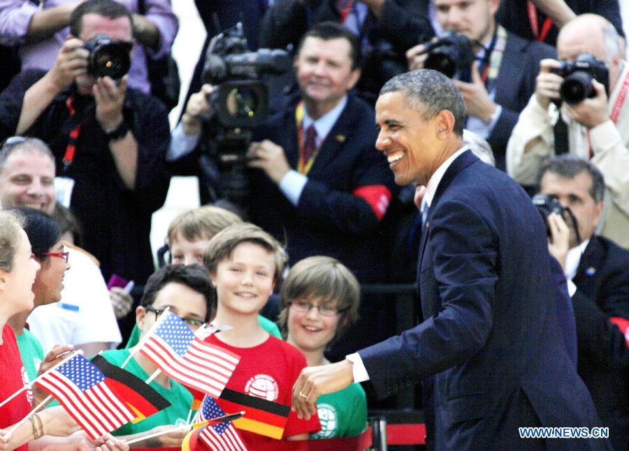 U.S. President Barack Obama greets people during a welcoming ceremony at the Presidential Palace in Berlin, Germany, June 19, 2013. Obama arrived in Berlin on June 18 for an official visit. (Xinhua/Pan Xu) 