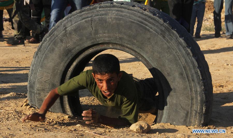 A Palestinian boy takes part in a military exercises during a military graduation ceremony organized by Hamas movement in the southern Gaza Strip city of Rafah on June 19, 2013. (Xinhua/Khaled Omar) 