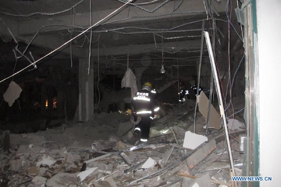 A fire fighter searches for survivors at the blast accident scene at a restaurant in Shuozhou City, north China's Shanxi Province, June 19, 2013. Blasts ripped through a restaurant in Shuozhou Wednesday night, killing two people and injuring over 150 others. The explosion of natural gas pipes was suspected to be the cause of the accident after an initial investigation. (Xinhua/Lu Xiaoyu)