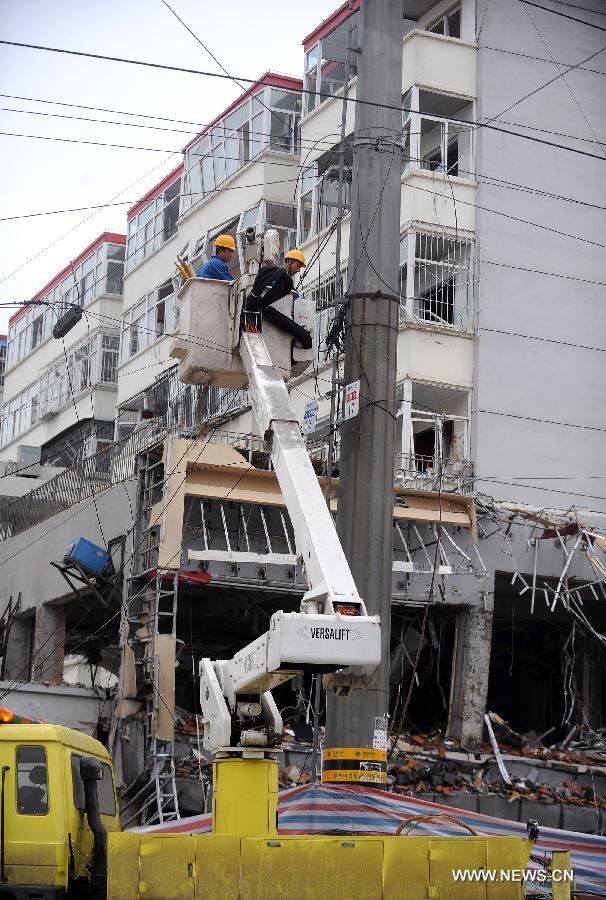 Workers remove the power cable destroyed by shockwave of a restaurant blast after finishing their work in Shuozhou City of north China's Shanxi Province, in the early morning of June 20, 2013. Blasts ripped through a restaurant in Shuozhou Wednesday night, killing three people and injuring 149 others. (Xinhua/Yan Yan)