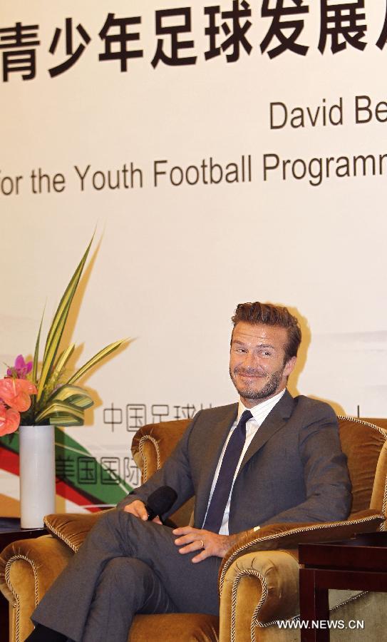 Former England soccer captain David Beckham smiles during a news conference in Shanghai, east China, June 20, 2013. Beckham arrived in China on Monday for a seven-day visit as the ambassador for the Youth Football Programme in China and China's Super League. (Xinhua/Fan Jun)