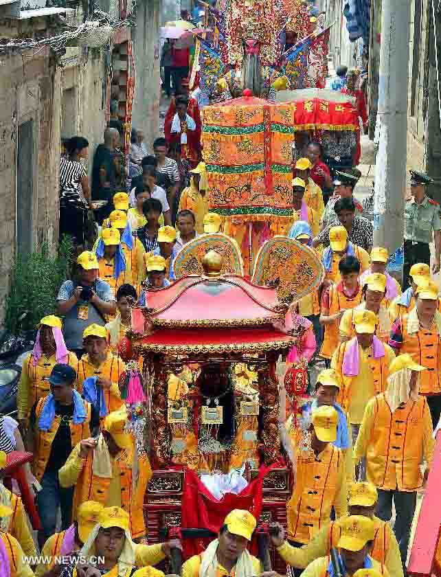 Locals participate in an annual parade honoring Guandi at Tongling Town in Dongshan County, southeast China's Fujian Province, June 20, 2013. Guandi, namely Guan Yu, was a senior general of shu han (221-263) during the three kingdoms period. Guan had been deified by feudal rulers of past ages because of his loyalty to his kingdom and was dubbed "guandi (emperor guan of military strategies)". Guan and confucius, known as the "emperor of education", were usually considered equal in status. (Xinhua/Wang Song) 