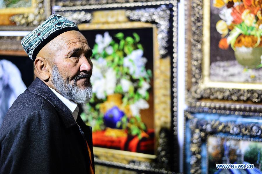 A visitor views decorational carpets at a Tibetan carpet exposition in Xining, capital of northwest China's Qinghai Province, June 20, 2013. Opened Thursday, the exposition attracted some 110 exhibitors from 9 countries. (Xinhua/Wu Gang) 