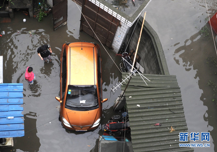 Local residents cope with heavy rainfall as water covered the streets in Chengdu, Southwest China's Sichuan province on June 19, 2013. 