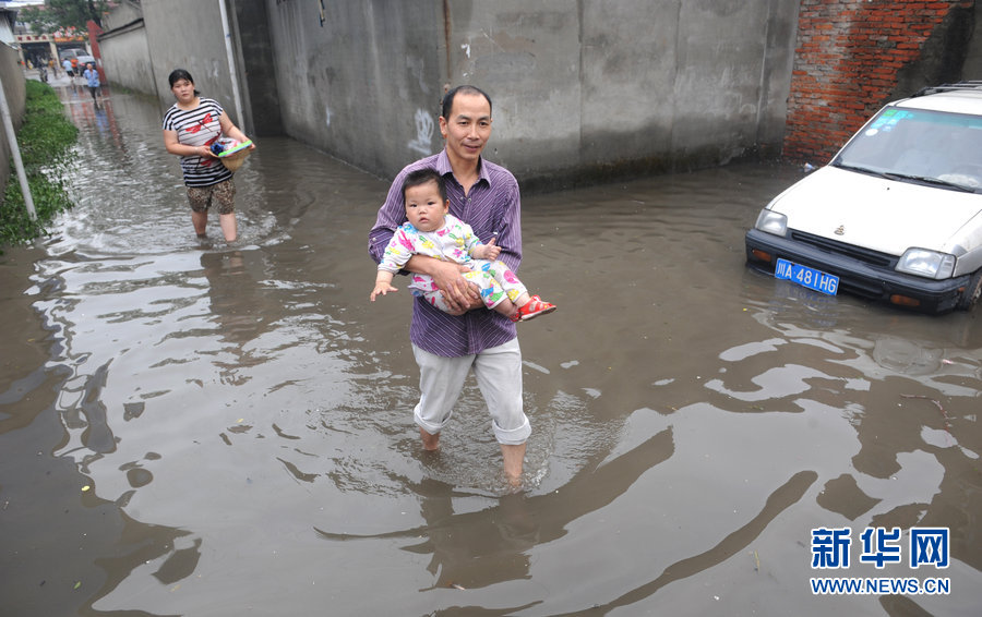 Local residents cope with heavy rainfall as water covered the streets in Chengdu, Southwest China's Sichuan province on June 19, 2013. Chengdu suffered a heavy rainstorm on Wednesday night which lasted until Thursday morning and water flooded many roads and fields in the city. No fatalities have been reported so far.
