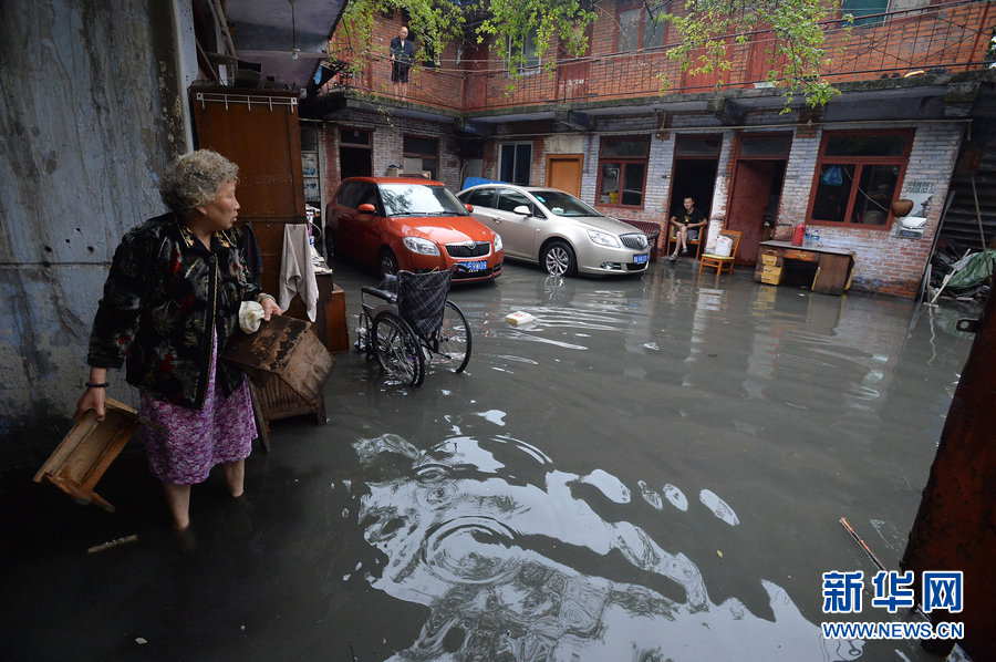 Local residents cope with heavy rainfall as water covered the streets in Chengdu, Southwest China's Sichuan province on June 19, 2013. 
