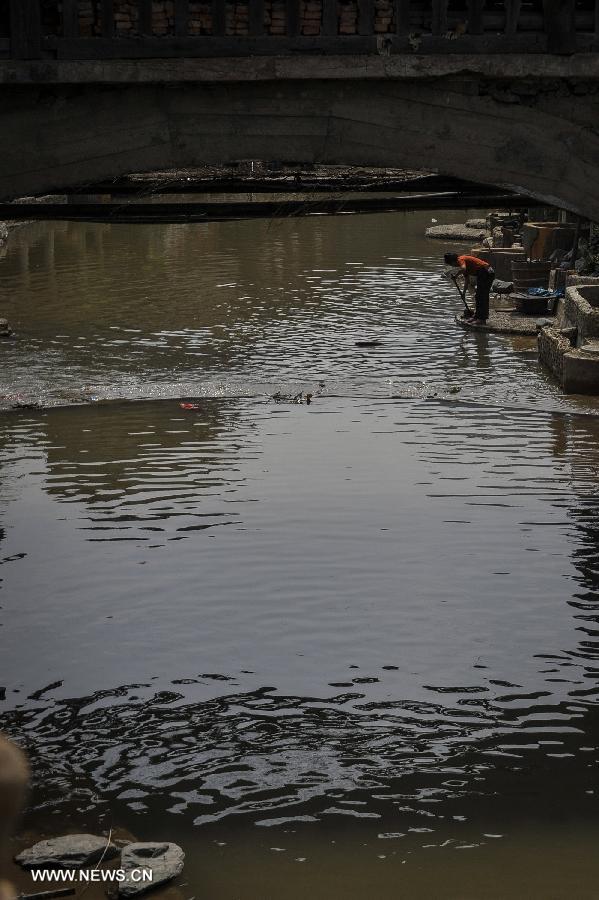 A woman of Dong ethnic group washes clothes near a brook at Zhaoxing Dong Village in Liping County, southwest China's Guizhou Province, June 20, 2013. Zhaoxing Dong Village is one of the largest Dong village in Guizhou. In 2005, it was ranked one of China's six most beautiful villages and towns by Chinese National Geography. (Xinhua/Ou Dongxu) 