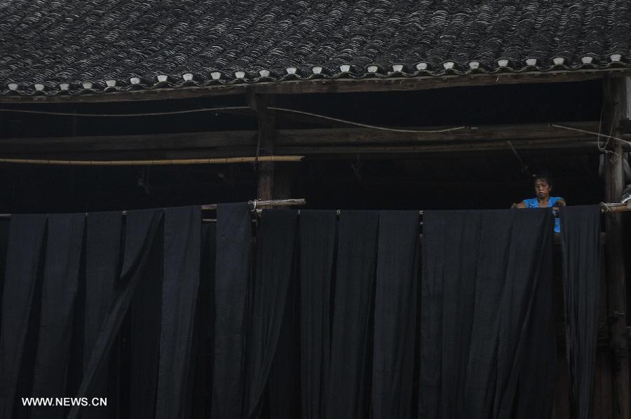 A woman of Dong ethnic group airs cloth at Zhaoxing Dong Village in Liping County, southwest China's Guizhou Province, June 20, 2013. Zhaoxing Dong Village is one of the largest Dong village in Guizhou. In 2005, it was ranked one of China's six most beautiful villages and towns by Chinese National Geography. (Xinhua/Ou Dongxu) 