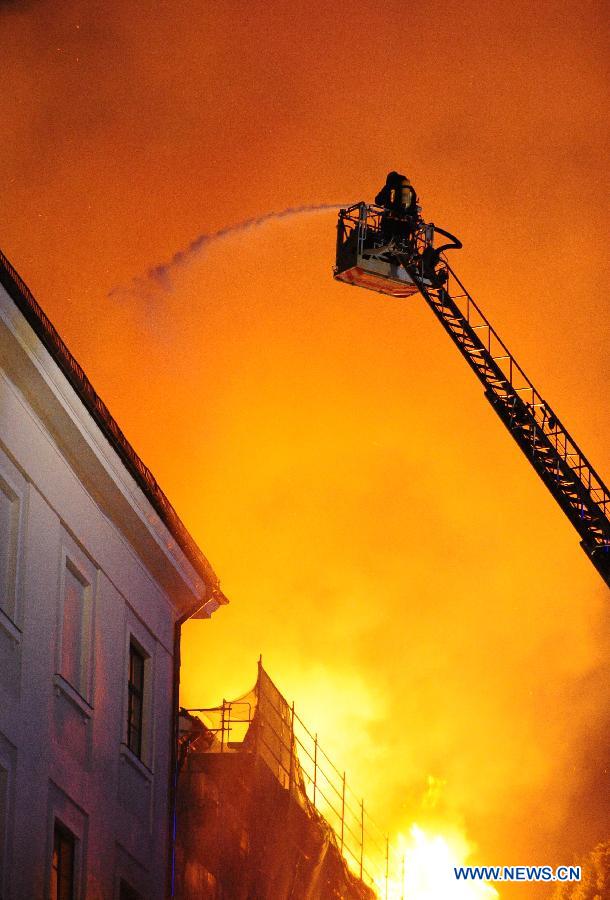 A firefighter tries to extinguish blaze on the roof of Riga Castle, Latvia, June 20, 2013. A massive roof fire was reported at the Riga Castle, office of the Latvian President. No casualty was reported. Due to ongoing renovation, the presidential office was temporarily moved to the Blackheads House, another historic landmark in the Latvian capital. (Xinhua/Guo Qun) 