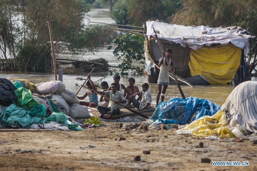 People transport belongings from their houses which were submerged by floodwaters of the Yamuna River in New Delhi, India, June 20, 2013. The Indian capital has been put on flood alert after its main Yamuna river breached the danger mark following incessant rainfall since June 16. So far, more than 150 people have died in Uttarakhand floods, while thousands have been displaced and stranded, according to reports. (Xinhua/Zheng Huansong) 