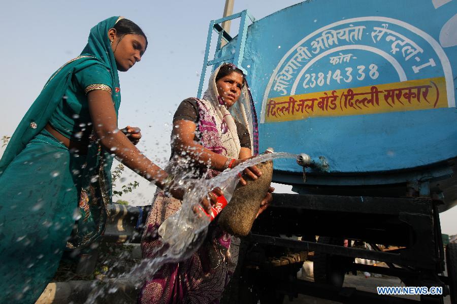 Homeless people get fresh water near the Yamuna River in New Delhi, India, June 20, 2013. The Indian capital has been put on flood alert after its main Yamuna river breached the danger mark following incessant rainfall since June 16. So far, more than 150 people have died in Uttarakhand floods, while thousands have been displaced and stranded, according to reports. (Xinhua/Zheng Huansong) 