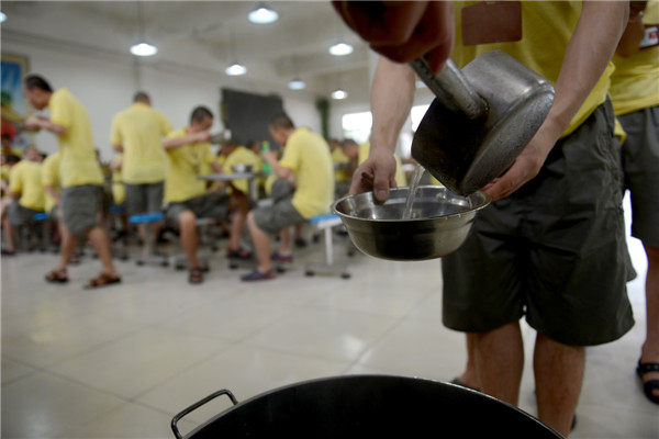 Addicts have supper at a drug rehabilitation center in Anhui province, June 19, 2013. "The days when I took drugs, I changed a lot in temper and became crusty and paranoid. After a year of drug control in the center, I've shrugged off many bad habits and become much better in body and mentality. Now I'm eager to find a job in my hometown after my drug control ends and spend more time with my family," said one drug addict. There are 500 addicts at the drug rehab center, which provides them with medical treatment, psychological counseling as well as skill training to help them return to society. [Photo/Xinhua]